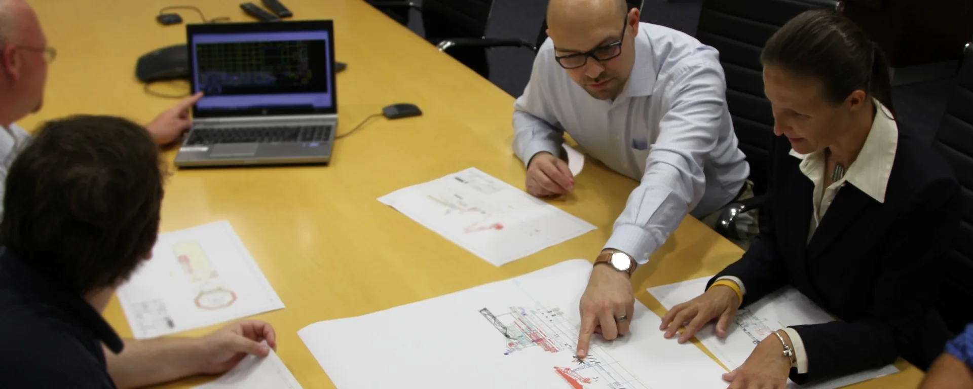 Filip Valica reviewing engineering drawings with colleagues during an offshore equipment design session